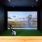 large screen and faux green in golf simulation room
